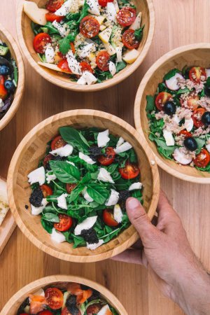 Téléchargez les photos : Une vue d'ensemble des salades à emporter saines dans des contenants jetables en papier écologique - en image libre de droit