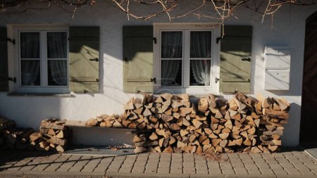 Photo for A stack of wood near the wall of a white rural house - Royalty Free Image