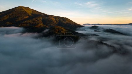 Photo for A daytime view of forests with pine trees and with mountains in the background on a foggy day in Mariazell, Austria - Royalty Free Image