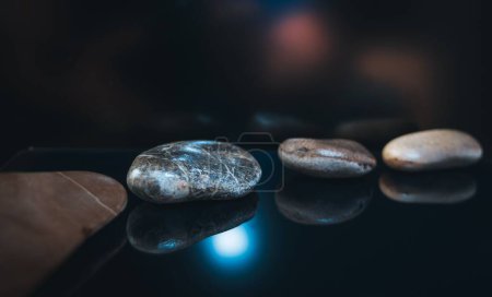Photo for A line of pebbles on a dark glowing surface - Royalty Free Image