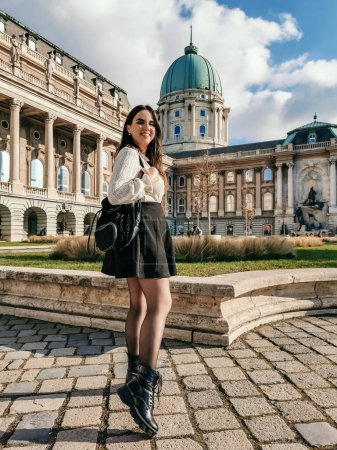 Téléchargez les photos : Une verticale d'une jolie jeune femme debout dans la cour du palais royal de Buda à Budapest - en image libre de droit