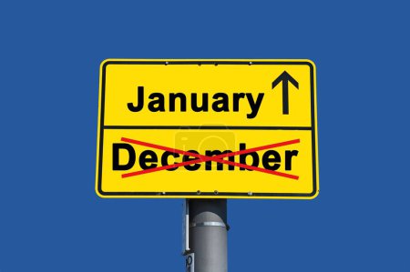 Foto de Signo amarillo con letras negras. Por debajo de la palabra diciembre tachado en rojo y por encima de ella la palabra enero con una flecha. - Imagen libre de derechos