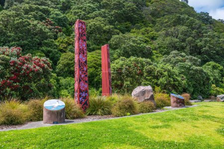 Téléchargez les photos : Une vue panoramique de sculptures tribales maories dans le parc Whakatane entouré de collines à feuilles persistantes - en image libre de droit