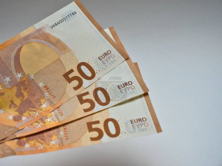 Téléchargez les photos : Trois billets de cinquante euros détenus sur un fond blanc - en image libre de droit