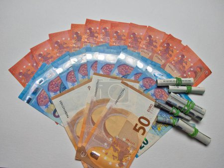 Foto de Billetes de diez, veinte, cincuenta euros en un semicírculo con pequeños rollos de billetes de cinco euros en el fondo - Imagen libre de derechos