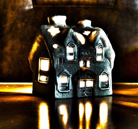 Téléchargez les photos : Un gros plan d'une jolie maison miniature avec une bougie à l'intérieur sur la table - en image libre de droit