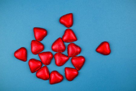 Photo for A top view of red heart-shaped chocolates on a blue background - the concept of Valentine's day - Royalty Free Image