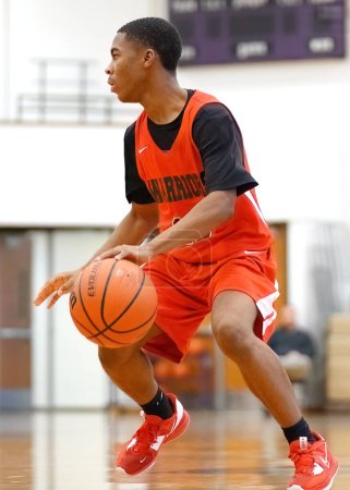Téléchargez les photos : Plan vertical d'un jeune joueur masculin sur le terrain lors d'un match de basket-ball du lycée de Merrillville - en image libre de droit