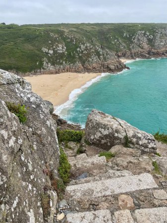 Foto de Un hermoso paisaje de una playa de arena de las piedras en un acantilado - Imagen libre de derechos