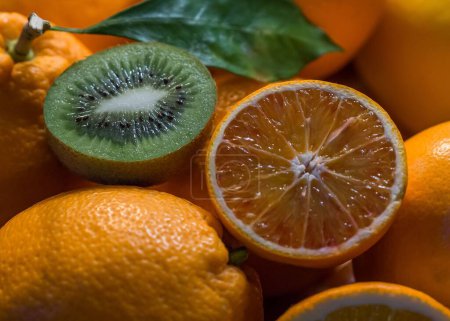 Foto de Un primer plano de diferentes tipos de frutas ricas en vitamina C. Naranja en rodajas, kiwis. - Imagen libre de derechos