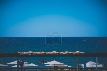 Foto de Una hermosa foto de sombrillas blancas en una playa con un fondo de paisaje marino - Imagen libre de derechos