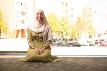 Foto de Un retrato de una hermosa mujer musulmana humilde sonriendo después de una oración en una mezquita - Imagen libre de derechos