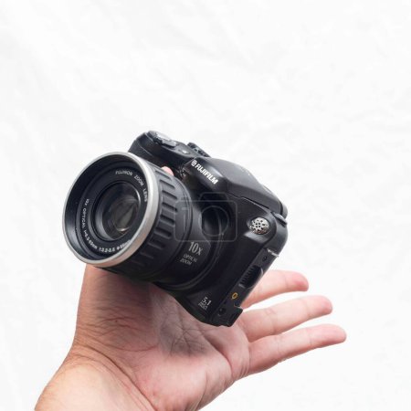 Foto de Una persona que sostiene una cámara compacta Fujifilm Finepix s5200 sobre un fondo blanco - Imagen libre de derechos