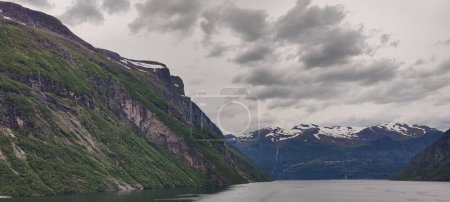 Téléchargez les photos : Une vue panoramique sur le fjord du Geirangerfjord et les montagnes Akerneset sous un ciel nuageux à Sunnmore, Norvège - en image libre de droit