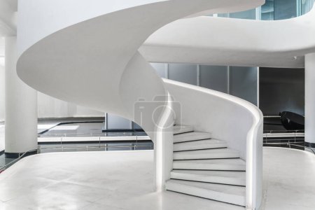Un escalier en colimaçon blanc dans un bâtiment moderne