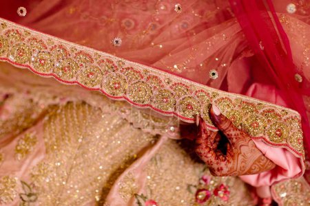 Foto de Hermosa novia india en traje tradicional de boda hindú con lehnga, brazaletes de novia y pose tímida - Imagen libre de derechos