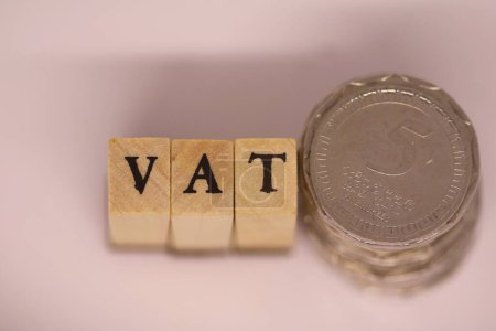 Foto de Bloque de cubo de madera vista superior con texto IVA con algunas monedas de rupia. Financiero, Gestión, Económico, Concepto de negocio - Imagen libre de derechos