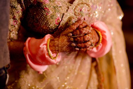 Foto de Hermosa novia india en traje tradicional de boda hindú con lehnga, brazaletes de novia y pose tímida - Imagen libre de derechos