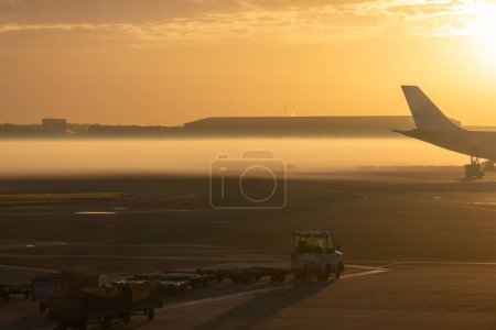 Photo for A sunset scene over Amsterdam Schiphol Airport planes with orange sky - Royalty Free Image