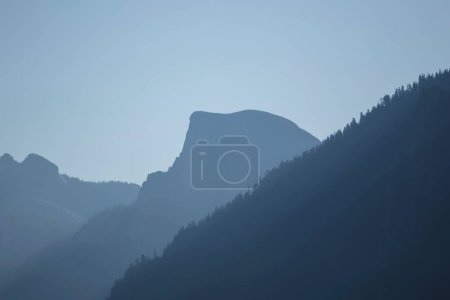 Foto de Una hermosa ilustración de montañas brumosas sobre un fondo azul - Imagen libre de derechos