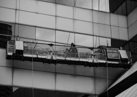 Téléchargez les photos : Échelle de gris d'un homme nettoyant les fenêtres d'un immeuble à Toronto - en image libre de droit
