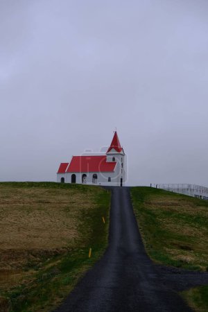 Foto de Un disparo vertical de un camino que conduce a la iglesia de Ingjaldsholl en Islandia bajo el cielo sombrío - Imagen libre de derechos