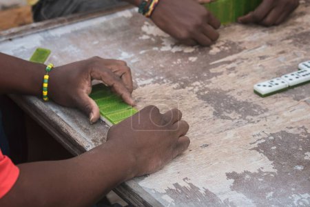 Foto de Un primer plano de manos negras jugando dominó en el barrio de La Marina Matanzas, Cuba - Imagen libre de derechos