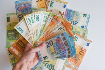 Foto de Mano humana que sostiene los billetes en euros en el contexto de los billetes - Imagen libre de derechos