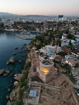 A beautiful view of a rocky shore of an island with buildings in Antalya, Turkey