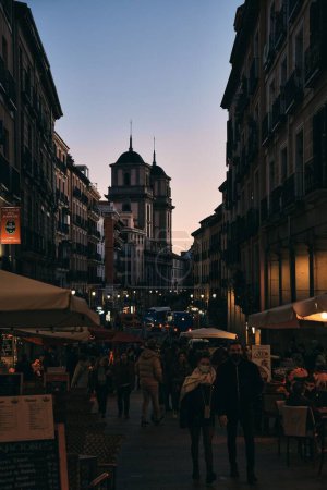 Téléchargez les photos : Une rue de Madrid bondée à la tombée de la nuit, ciel violet et clair en arrière-plan - en image libre de droit