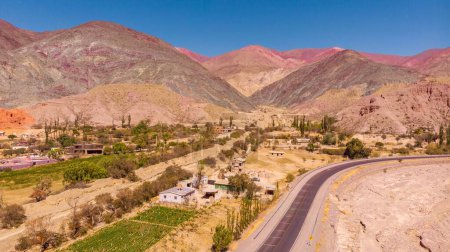 Téléchargez les photos : Une vue paysage avec montagne et collines colorées par une journée ensoleillée, ville Purmamarca à Jujuy, Argentine - en image libre de droit