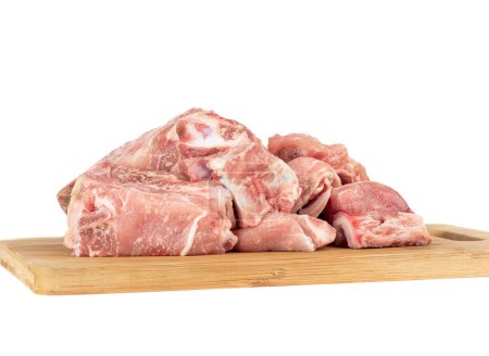 Foto de Trozos de carne de cerdo en una tabla de cortar de madera aislada sobre fondo blanco. Copiar espacio - Imagen libre de derechos