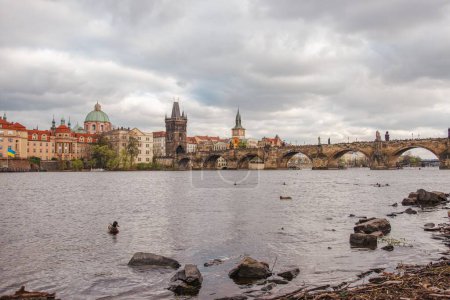Foto de Una vista panorámica del puente medieval de Carlos sobre el tranquilo río Moldava en Praga, Chequia - Imagen libre de derechos