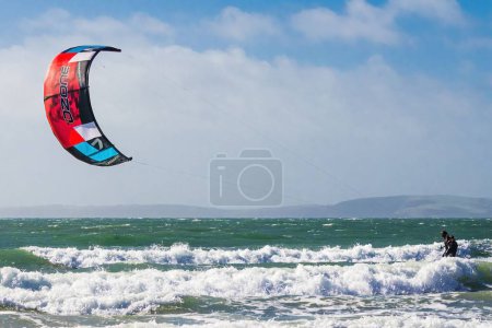 Téléchargez les photos : Vue panoramique d'une personne faisant du kitesurf sur une belle plage lors d'une journée d'été en Irlande - en image libre de droit