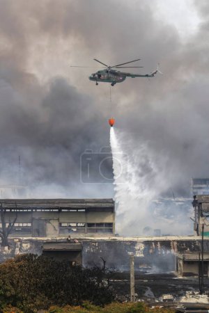 Foto de Un disparo vertical del helicóptero de las fuerzas armadas cubanas, apagando el fuego de la explosión de los tanques de petróleo del superpetrolero en Matanzas Cuba - Imagen libre de derechos
