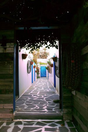 Téléchargez les photos : Plan vertical d'une passerelle avec décor sur les murs menant à une porte bleue à Batroun, Liban. - en image libre de droit