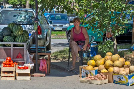 Foto de Una vendedora sonriente sentada bajo una sombra y vendiendo sandías en la calle en Zrenjanin, Serbia - Imagen libre de derechos