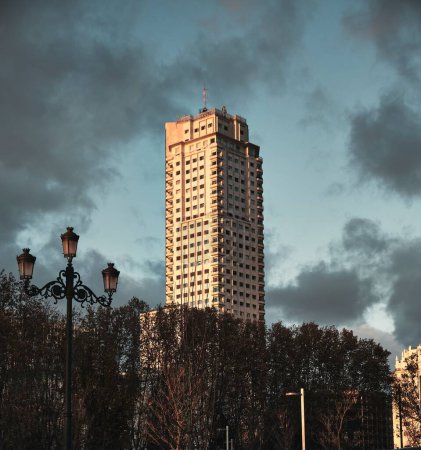 Photo for A sunlit skyscraper tower of Madrid at sunset, cloudy sky background - Royalty Free Image
