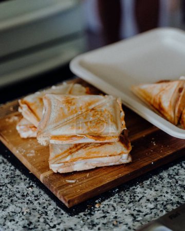 Photo for A close-up shot of hot toasted Triangle sandwiches on a wooden board - Royalty Free Image