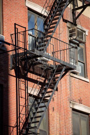 Foto de Un disparo vertical de una escalera de escape de incendios de un edificio de ladrillo en Nueva York, Estados Unidos. - Imagen libre de derechos