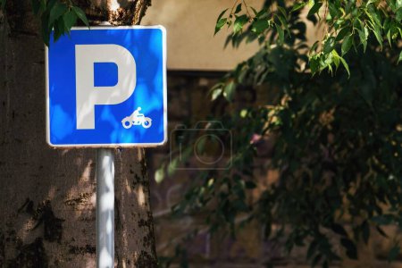 Photo for A closeup of a free parking sign on the street with trees in the background - Royalty Free Image