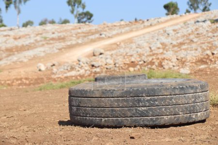 Téléchargez les photos : Plan rapproché d'un vieux pneu usagé laissé sur un champ - en image libre de droit