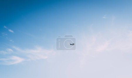 Foto de Una toma de ángulo bajo de un avión volando en un cielo azul - Imagen libre de derechos