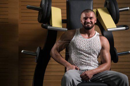 Téléchargez les photos : Un beau jeune homme beau et attrayant avec le corps musculaire relaxant dans la salle de gym - en image libre de droit