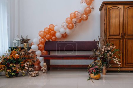 Photo for A bench with a floral bouquet on the side and balloons hanging on top for an event - Royalty Free Image