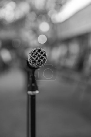 Téléchargez les photos : Un plan vertical monochrome du microphone sur le stand avec un fond bokeh - en image libre de droit