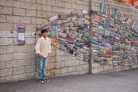 Foto de Un chico coreano cerca del muro de arte en Gamcheon Culture Village - Imagen libre de derechos