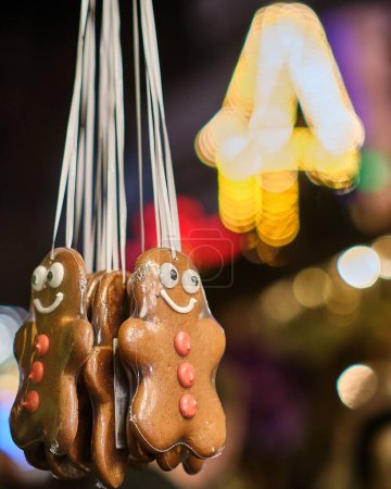 Photo for A vertical night shot of smiling gingerbread figures with glowing blurred background at the Christmas market in Bonn, Germany - Royalty Free Image