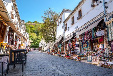 Téléchargez les photos : Une rue avec des touristes et des boutiques de souvenirs à Gjirokaster, Albanie - en image libre de droit