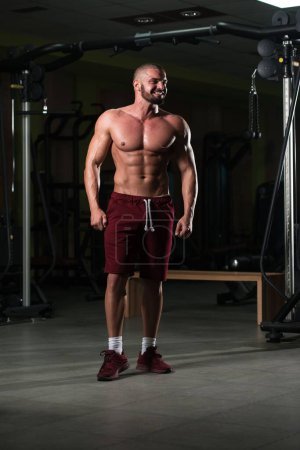 Photo for A vertical portrait of an attractive fitness model showing of his athletic body after a workout - Royalty Free Image